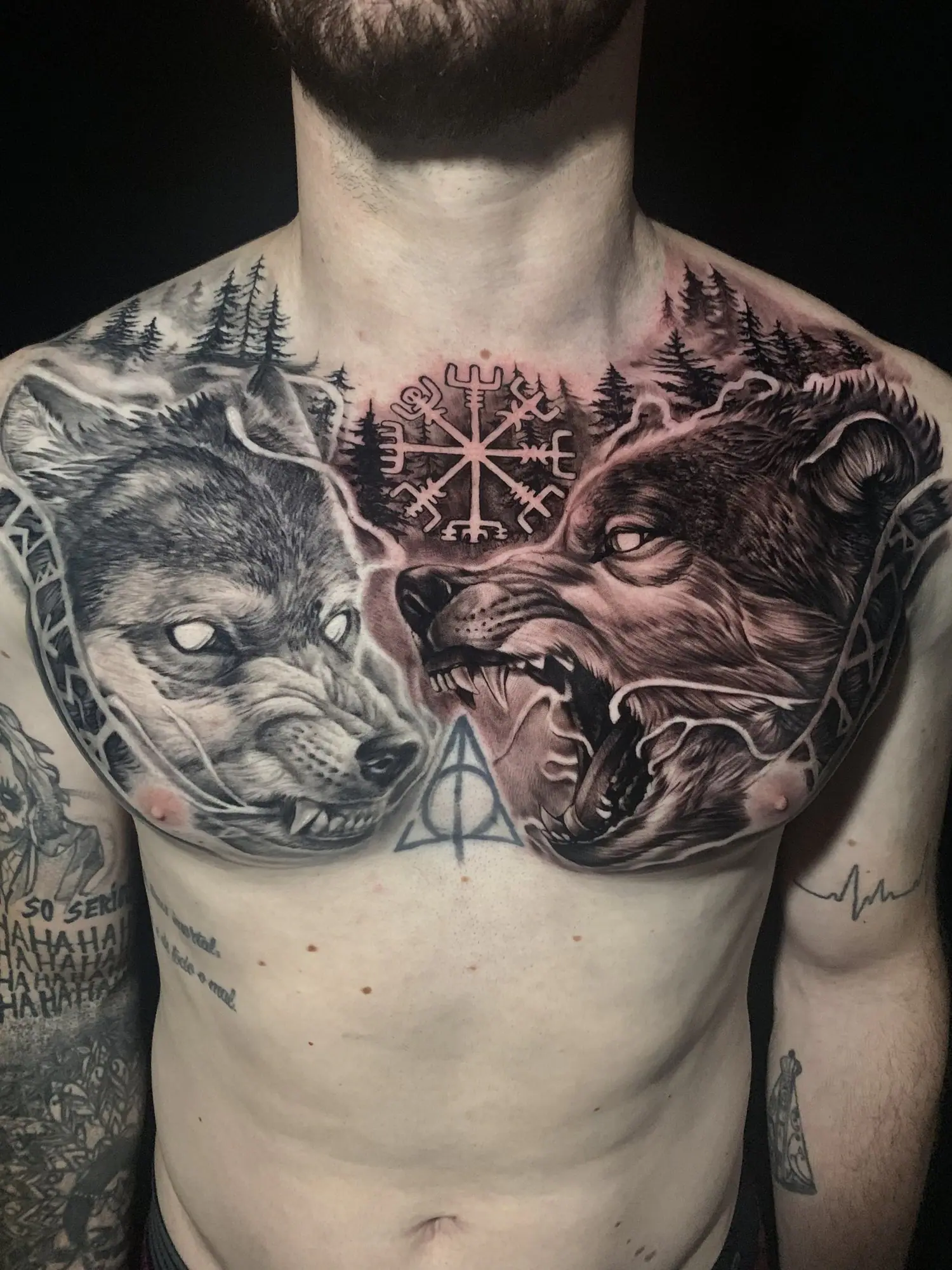 Dois lobos e símbolo nórdico em realismo fechando o peito