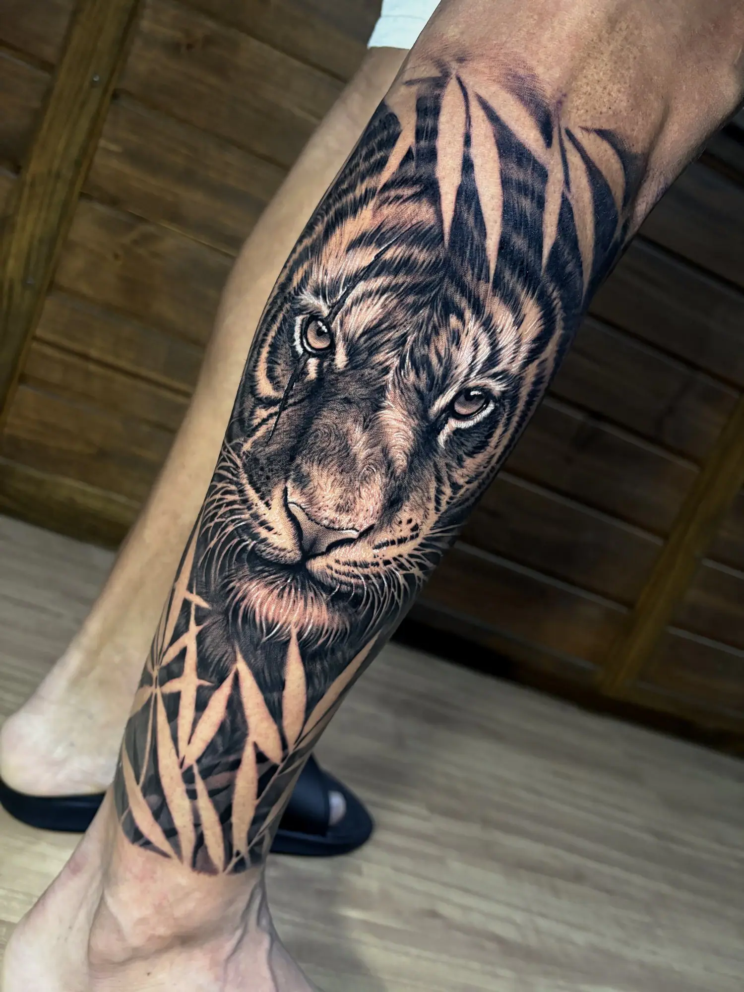 Tigre entre folhagens em realismo no antebraço
