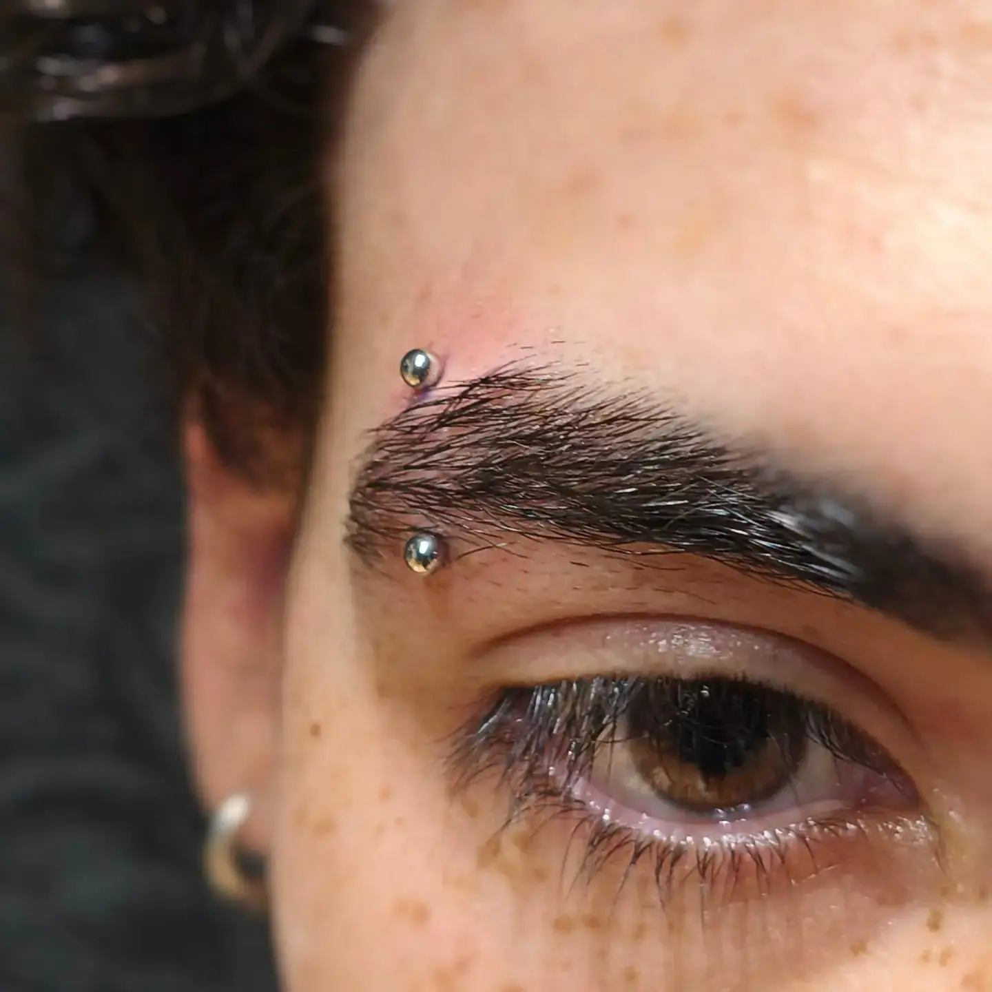 Piercing na sobrancelha com microbell curvo de titânio